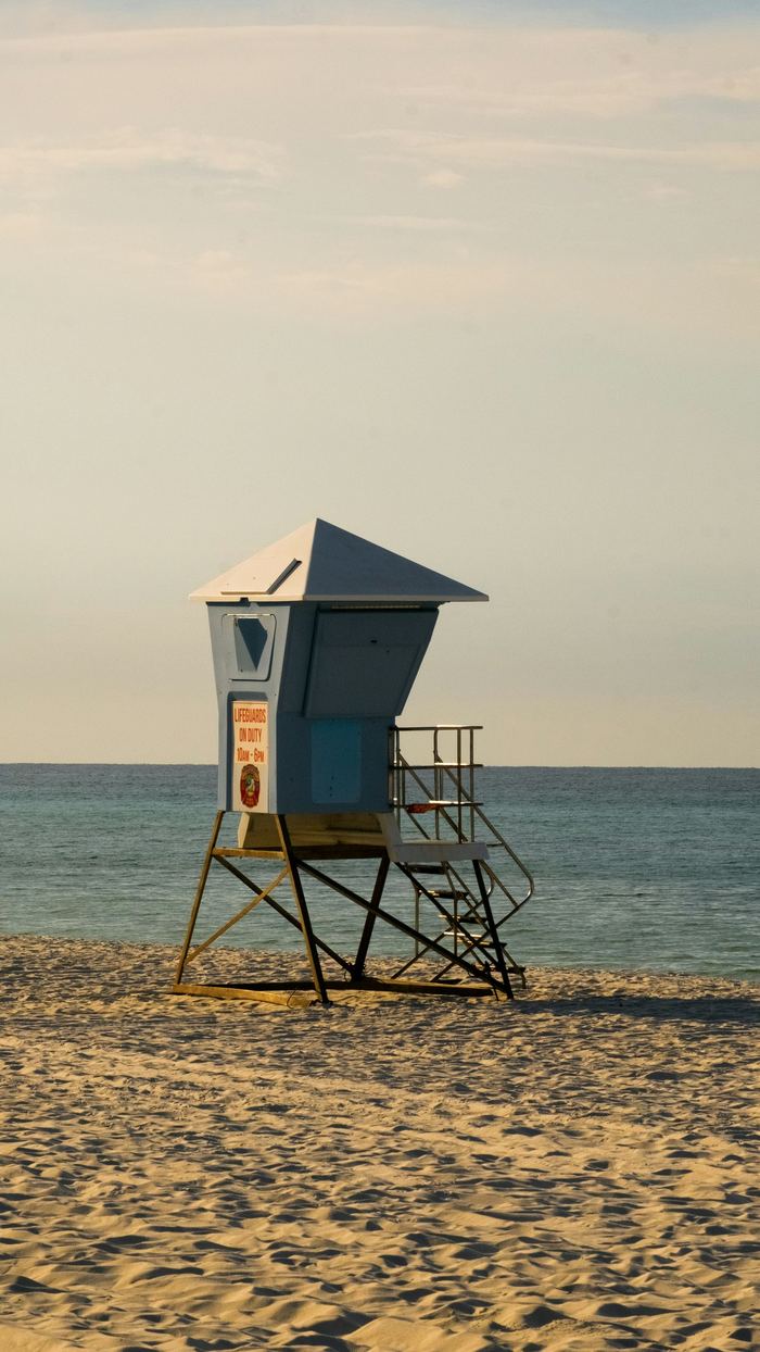 Blue lifeguard stand on an empty beach in soft light